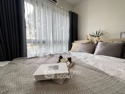 Cozy bedroom with elegant decor and large window offering natural light.