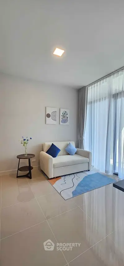 Modern living room with cozy sofa and stylish decor in bright natural light.