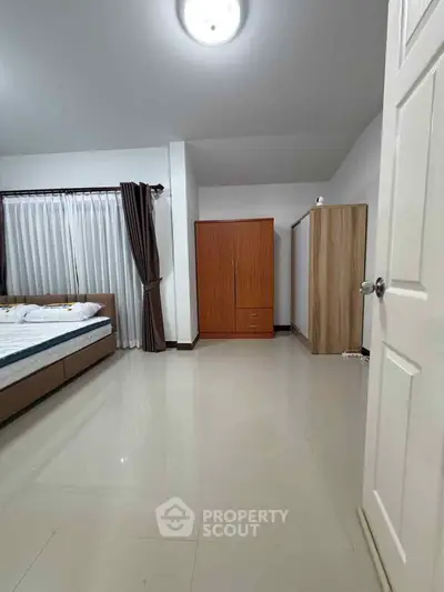 Spacious bedroom with modern furnishings and ample natural light