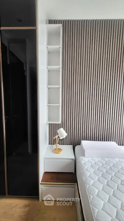 Modern bedroom with stylish wood paneling and sleek furniture design.