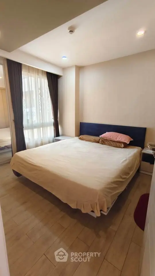 Cozy bedroom with large window and modern furnishings, perfect for relaxation and comfort.