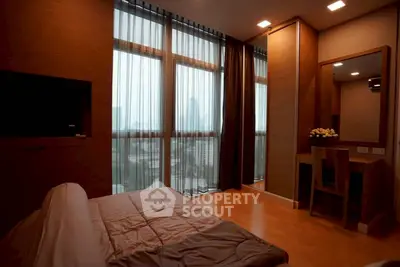 Luxurious bedroom with floor-to-ceiling windows and city view in modern apartment.