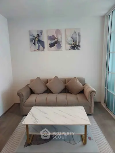 Chic living room with elegant sofa, marble coffee table, and floral wall art for modern comfort.