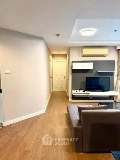 Modern living room with sleek furniture and wooden flooring in a cozy apartment.