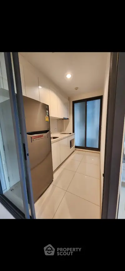 Modern kitchen with sleek cabinetry and stainless steel appliances in a compact layout.