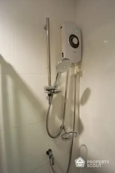 Modern bathroom with sleek electric shower unit and adjustable shower head, featuring clean white tiles for a minimalist aesthetic.