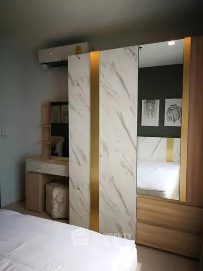 Modern bedroom with stylish wardrobe and air conditioning unit, perfect for comfort and elegance.