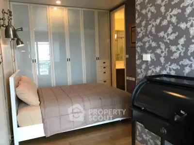 Stylish bedroom with modern decor and ample closet space in a cozy apartment.