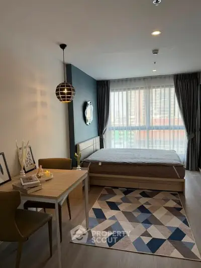 Modern bedroom with stylish decor and natural light, featuring a cozy dining area.