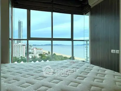 Luxurious bedroom with stunning ocean view and floor-to-ceiling windows.