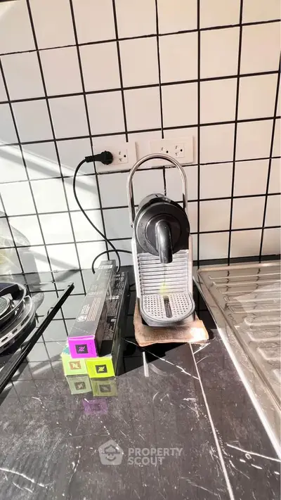 Modern kitchen corner with sleek coffee machine and stylish tile backsplash.