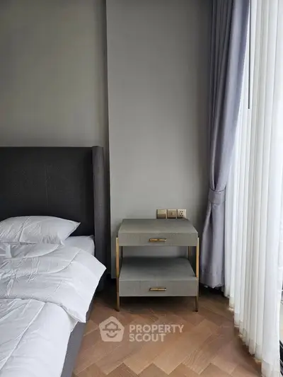 Modern bedroom with elegant side table and floor-to-ceiling window drapes