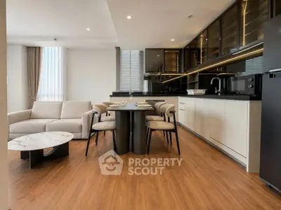 Modern open-layout kitchen and living room with sleek design and wooden flooring.
