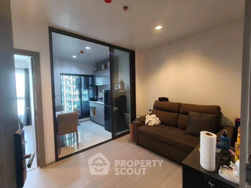 Modern living room with glass partition and cozy seating area in a stylish apartment.