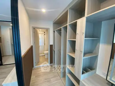 Spacious walk-in closet with modern shelving and bathroom access in contemporary apartment.