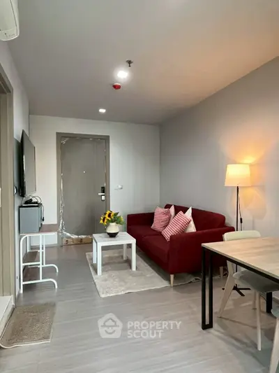 Modern living room with red sofa, stylish decor, and cozy lighting