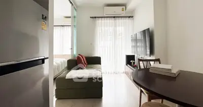 Modern living room with cozy sofa, wall-mounted TV, and dining area in bright apartment.