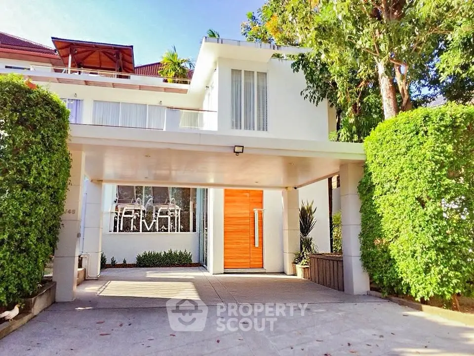 Modern two-story house with lush greenery and spacious driveway