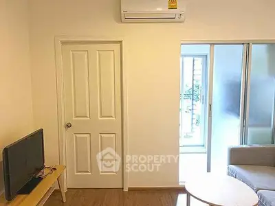 Cozy living room with modern air conditioning and sliding glass door to balcony.