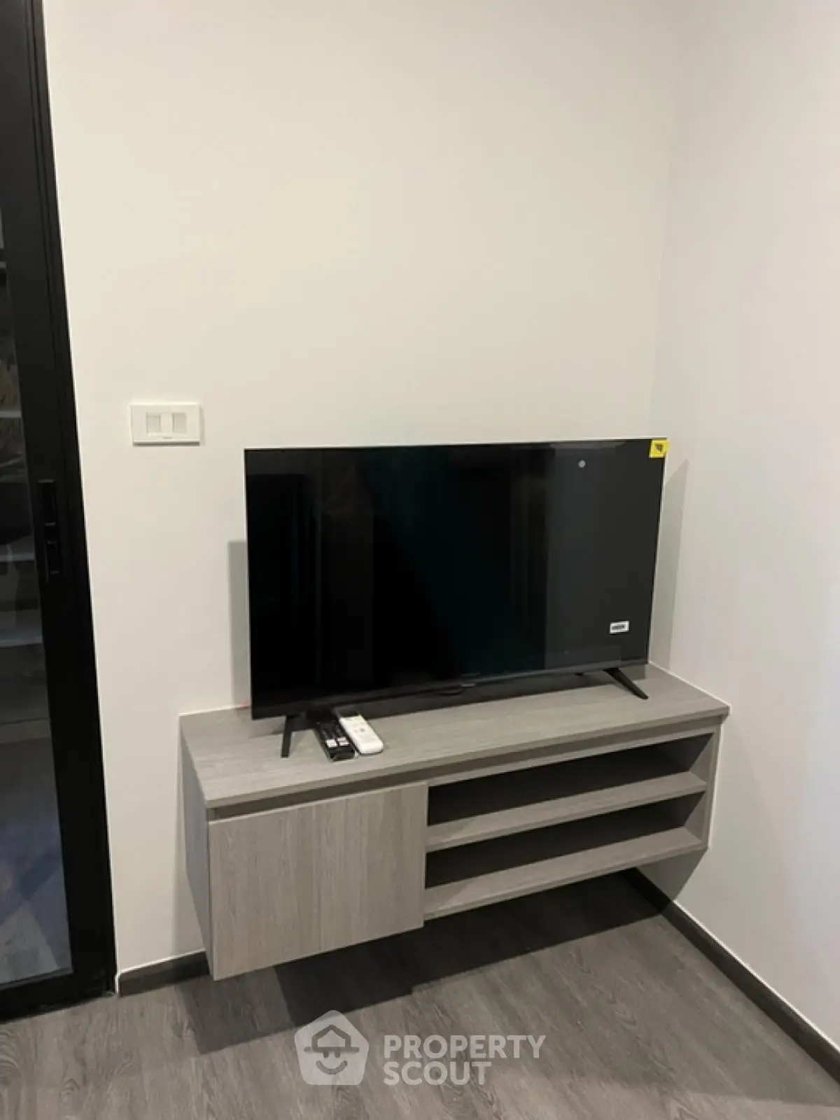 Modern living room corner with sleek TV stand and flat-screen TV, perfect for entertainment setup.