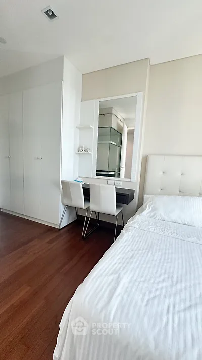 Modern bedroom with sleek design, featuring a cozy bed, stylish desk, and ample closet space.