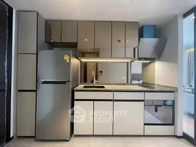 Modern kitchen with sleek cabinetry and stainless steel appliances in a stylish apartment.