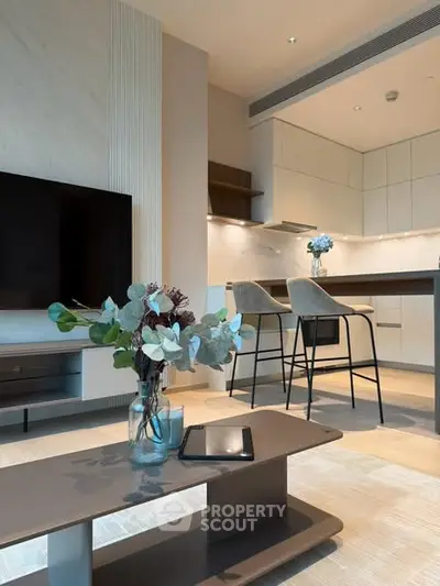 Modern open-plan living room and kitchen with stylish decor and natural light.
