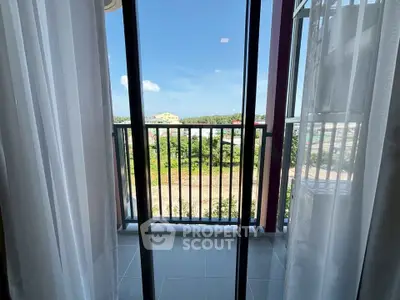 Charming balcony view with lush greenery and clear blue sky, perfect for relaxation.