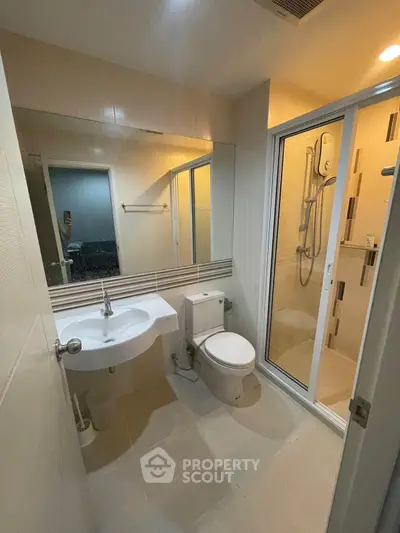 Modern bathroom with shower enclosure and sleek fixtures in a contemporary apartment.