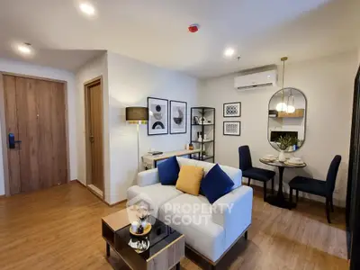 Modern living room with stylish decor, cozy seating, and elegant dining area in open-plan apartment.