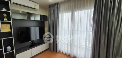 Modern living room with sleek TV setup and large window with curtains