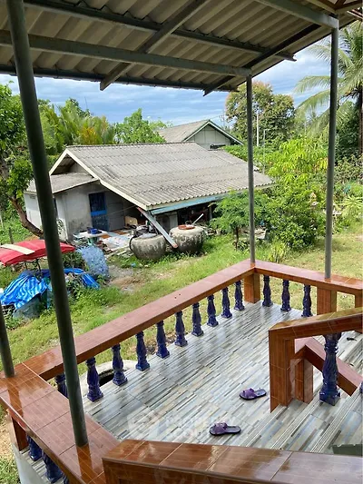 Charming rural home with spacious balcony and lush garden view.