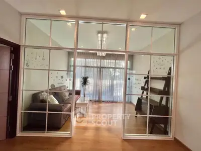 Spacious living room with elegant glass partition and modern decor