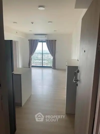 Spacious modern apartment with large windows and balcony offering stunning views.