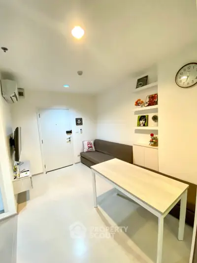 Modern living room with sleek furniture and wall-mounted TV in a cozy apartment.