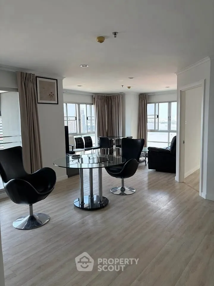 Modern living room with sleek furniture and large windows offering ample natural light.