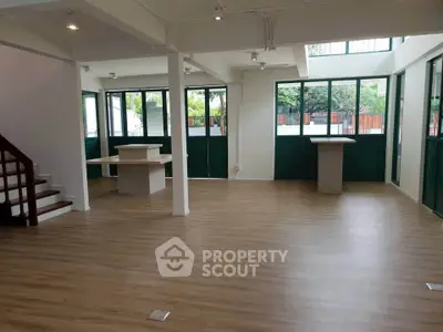 Spacious open-plan interior with large windows and modern flooring, perfect for versatile living or office space.