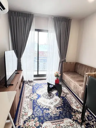 Stylish living room with elegant decor, plush sofa, and large window offering city views.