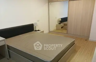 Spacious bedroom with modern design and large mirrored wardrobe