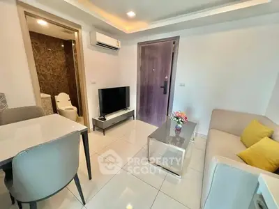 Modern living room with sleek furniture and open layout, featuring a TV and dining area.