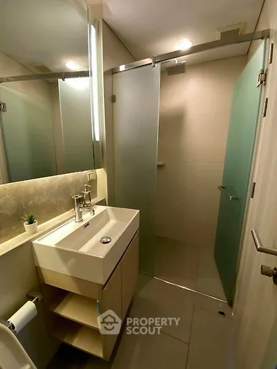 Modern bathroom with sleek shower and stylish vanity in contemporary apartment.