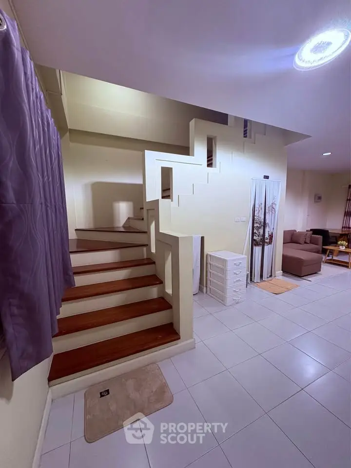Modern interior with stylish staircase and cozy living area, perfect for contemporary living.