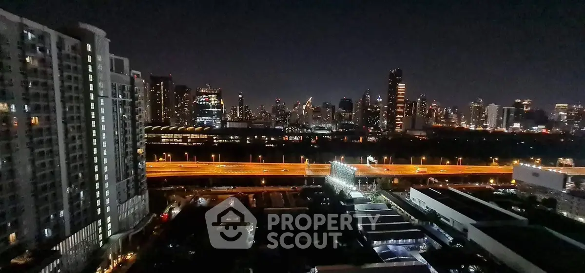 Stunning city skyline view from high-rise apartment at night, showcasing vibrant urban lights and modern architecture.