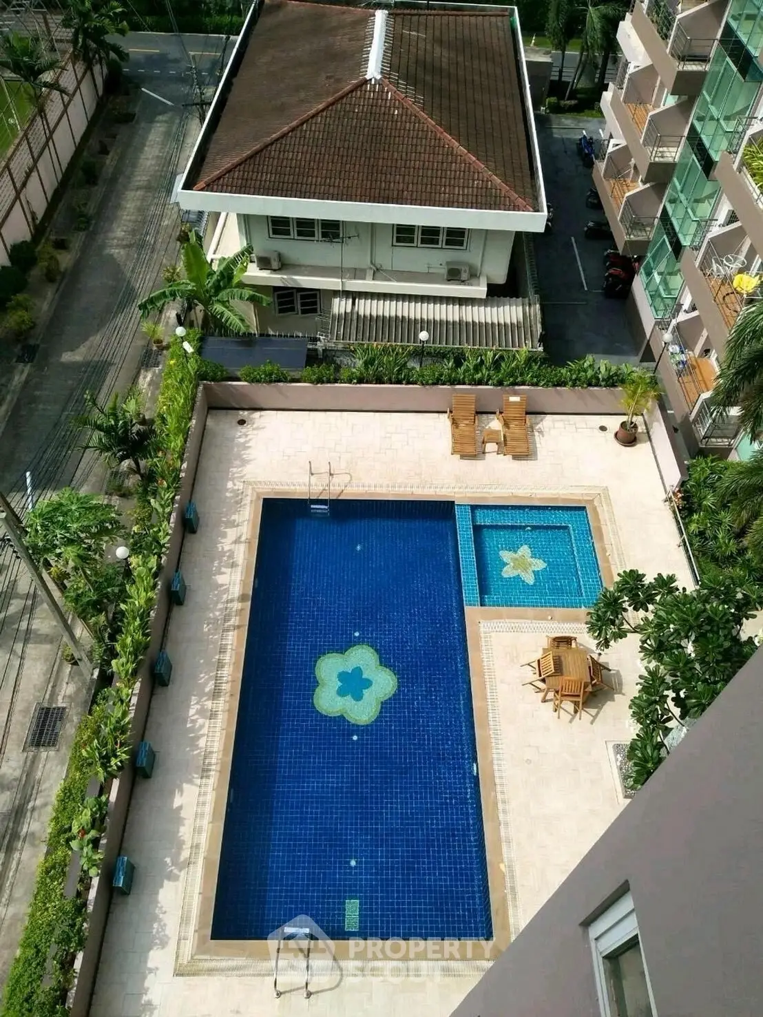Stunning aerial view of a luxurious residential pool with elegant design and lush surroundings.