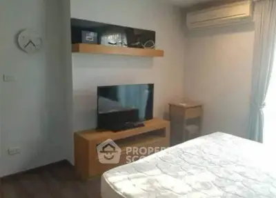 Cozy bedroom with modern decor and air conditioning, featuring a TV and stylish shelving.