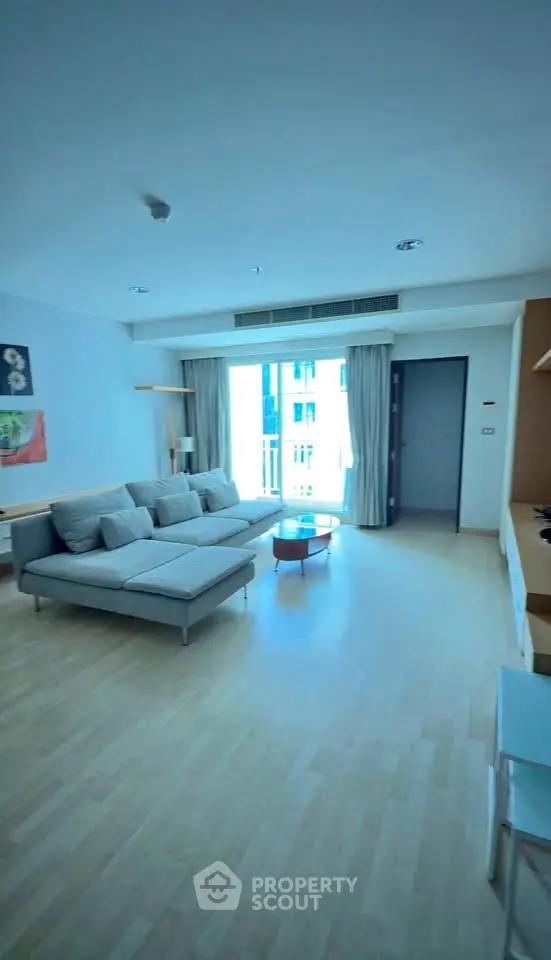 Spacious modern living room with large windows and stylish furniture in a bright apartment.