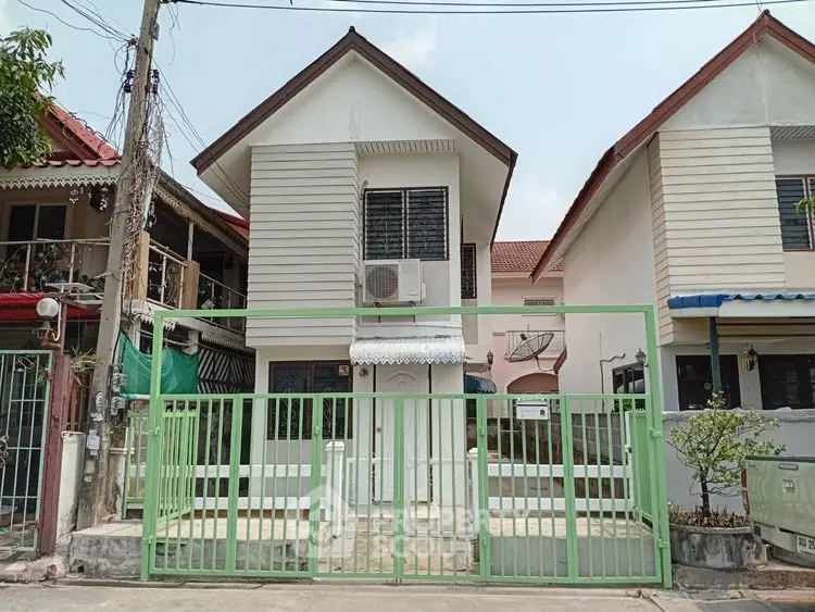 Charming two-story house with green fence and modern exterior design