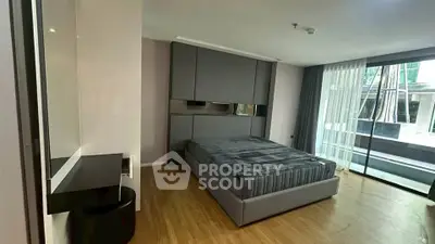 Modern bedroom with sleek design and large window offering natural light