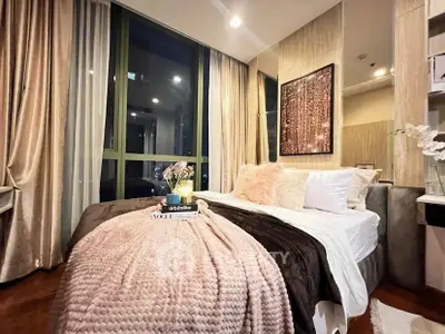 Luxurious bedroom with elegant decor and large windows offering city views.