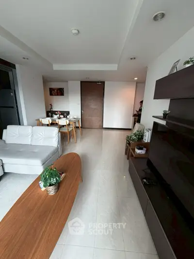 Modern living room with sleek furniture and dining area, perfect for stylish urban living.